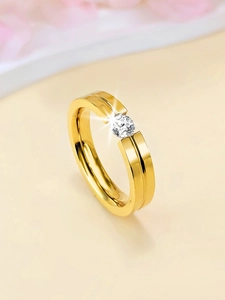 Macro shot of a gold tension set ring featuring a brilliant round cut clear gemstone