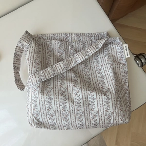 Detail of floral stripe pattern cotton fabric with simple wish woven label on bag side