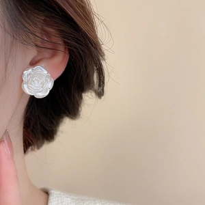 Dettaglio elegante orecchino a perno a rosa in resina bianca lucida su modella