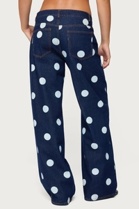 Detail view of high-waist navy blue denim pants with white polka dots and back pockets