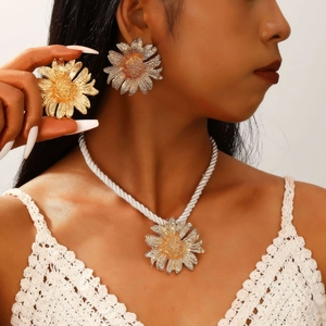 Detail of golden sunflower earrings and necklace set with white braided cord on model