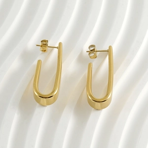 Boucles d'oreilles minimalistes en forme de U en acier inoxydable doré sur fond blanc