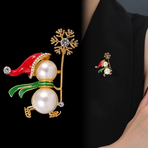 Broche bonhomme de Noël avec perles et bonnet rouge sur un revers de veste noir