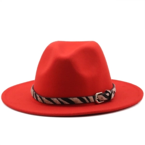 Detail of red wool fedora hat with zebra print band and silver metal buckle