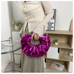Detail der fuchsia-metallic Handtasche mit Falten-Struktur und glänzender Oberfläche im Detail