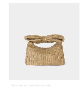 Detail showing handwoven straw texture and large bow handle on light brown handbag
