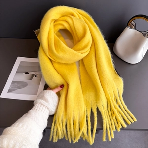 Détail de l'écharpe en mohair jaune montrant la texture douce et les longues franges