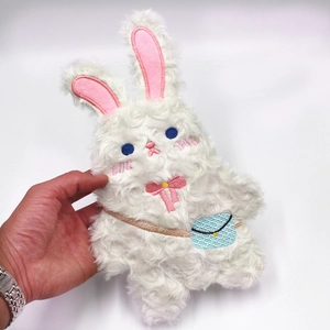 Détail de la trousse lapin en peluche blanche avec yeux bleus et nœud rose