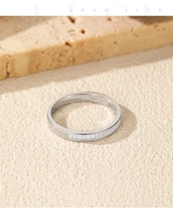 Close-up of baguette-cut stones in a silver channel setting on a textured surface