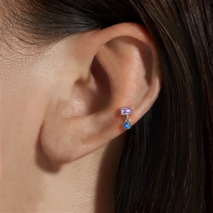 Detail of S925 sterling silver earring with purple opal and blue stone on ear