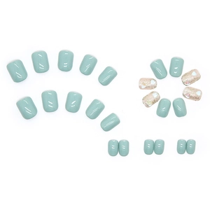 Short mint green press-on nails set with glitter accents and 3D white heart charms