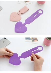 Pink and purple heart-shaped faux leather luggage tags with debossed text for suitcases