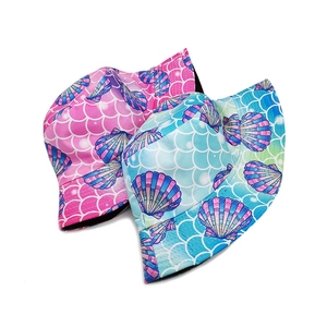 Détail de chapeaux de soleil réversibles avec motifs de coquillages et écailles de sirène