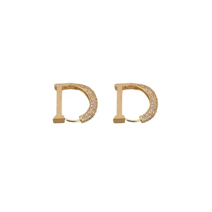Golden D-letter huggie earrings with cubic zirconia pavé setting on white background