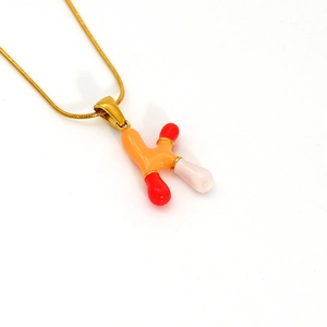 Close-up of golden necklace with colorful dopamine-style letter K pendant and snake chain