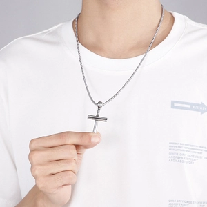 Detailed close-up of a silver stainless steel cross pendant featuring baseball bat elements