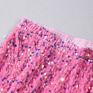 Détail de paillettes roses sur tissu velours pour pantalon de fête chic à taille haute