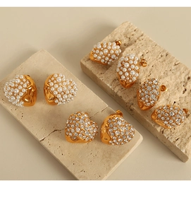 Detail of 18K gold plated heart and oval earrings with white pearls and crystals