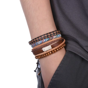 Détail de bracelets nautiques multicouches avec ancre sur le poignet d'un mannequin homme