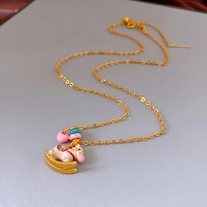 Detailed macro view of a golden necklace featuring a colorful enamel rocking horse charm