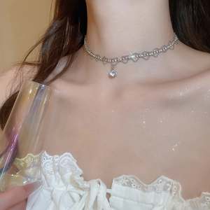 Detail shot of a silver zircon choker necklace with wave chain on model neck