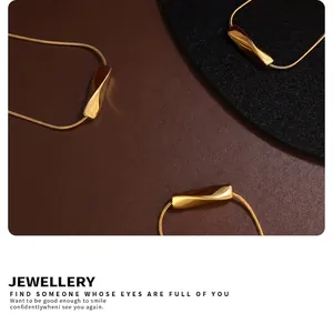 Detailed view of three twisted tube 18K gold plated stainless steel necklaces on felt mats