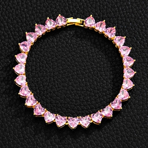 Detailed view of pink heart-shaped zircon tennis chain on black leather background