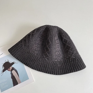 Close-up of dark grey cable-knit fisherman hat with detailed ribbed texture and weave