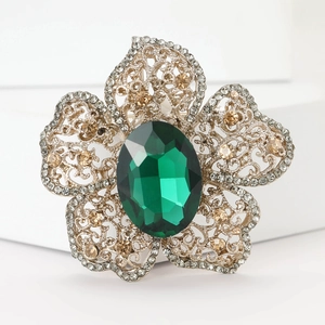 Vue détaillée de la broche fleur vintage dorée avec pierre émeraude et cristaux