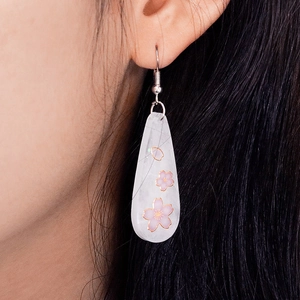 DIY resin teardrop earrings with pink cherry blossoms and gold flakes on model