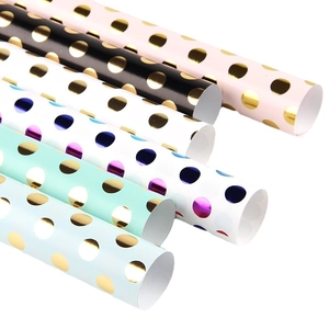 Pastel gift wrapping paper rolls with metallic gold polka dots for birthday and holiday
