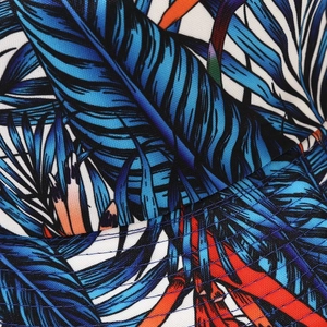 Detailed macro view of tropical palm leaf print fabric with durable blue double stitching