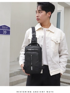 Close-up of waterproof black crossbody chest bag worn by a model in casual street style