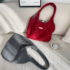 Dettaglio della borsa tote in tela con paillettes a stella, etichetta e fodera a quadri