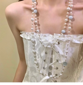 Detailed view of baroque pearl and light blue cat-eye beaded multilayer necklace