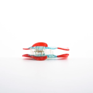 Detail of tropical fish acetate hair claw with blue marble texture and red accents