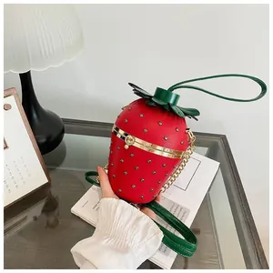 Détail du sac seau fraise rouge avec rivets et bandoulière en chaîne dorée