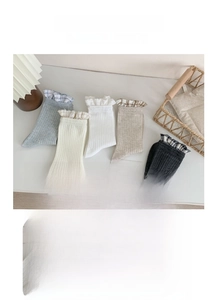Detailed view of ribbed cotton crew socks with delicate lace trim in neutral color tones