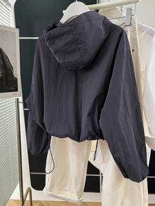 Back view of dark grey cropped zip-up hoodie featuring an adjustable drawstring hem