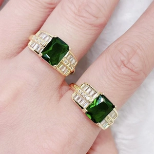 Detail view of gold vintage ring featuring emerald-cut green zircon and pavé crystals