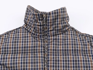 Close-up of stand collar on blue and brown plaid jacket with metal zipper detail