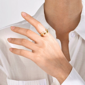 Elegant gold chevron ring with white zircons worn on model with clean white background
