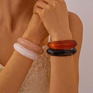 Detailed shot of textured resin bangles in marble pink, white, amber, and black colors