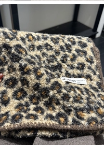 Close-up of leopard print wool-like scarf showing texture and NF DESIGN brand label