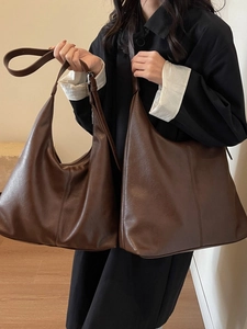 Deep brown soft leather tote bag set in large and medium sizes on a casual model