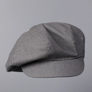 Detailed macro view of the striped cotton fabric and metal eyelets on the newsboy cap