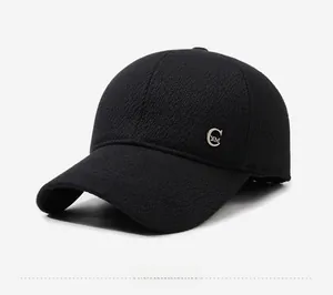 Detailed side view of black textured baseball cap with metallic CYM badge and curved brim