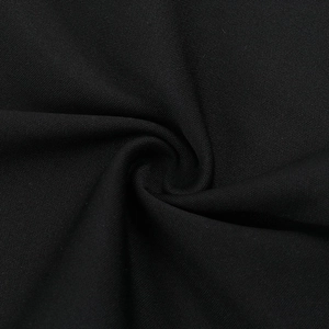 Gros plan sur la texture du tissu côtelé noir et les coutures fines du caraco Y2K