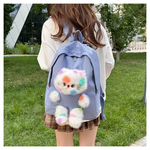 Foto all'aperto di uno zaino in tela viola con un simpatico gatto di peluche bianco