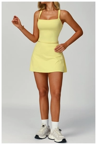 Vista de detalle del conjunto deportivo amarillo de dos piezas con top y falda de fitness